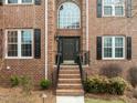 Inviting front entrance with a brick facade, arched window, and elegant landscaping at 105 Aberson Ct, Cary, NC 27519