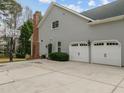 Spacious three-car garage with a basketball hoop in the driveway at 105 Aberson Ct, Cary, NC 27519