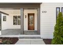 Inviting entryway showcasing a wooden front door, stone tile porch, and well-manicured shrubbery at 109 W Markham Ave, Durham, NC 27701
