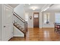 Inviting foyer featuring hardwood floors, a staircase with decorative iron railings, and natural light at 1328 Mill Glen Cir, Raleigh, NC 27614