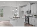 Bright kitchen features white cabinets, stainless steel appliances, and a center island with pendant lighting at 1329 Channing Park Cir, Cary, NC 27519