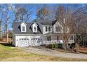Side view of a white, two-story house with a two-car garage and well-maintained lawn and driveway at 15 Rocky Point Ct, Fuquay Varina, NC 27526