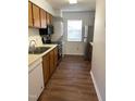 Efficient kitchen with stainless steel appliances, wooden cabinets, and a convenient stacked washer/dryer at 151 Schultz St # 151, Chapel Hill, NC 27514