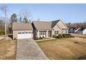 Well-maintained one-story home with an attached garage, long driveway, and manicured front lawn at 16 Eagle Swoop St, Zebulon, NC 27597