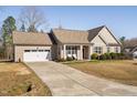 Attractive single Gathering home featuring a long driveway and inviting entrance with covered front porch at 16 Eagle Swoop St, Zebulon, NC 27597