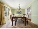 Formal dining room features a large table with seating for eight and modern chandelier at 1708 Lakepark Dr, Raleigh, NC 27612