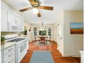 Eat-in kitchen boasts wooden floors, white cabinets, gas range, and bright breakfast nook at 1708 Lakepark Dr, Raleigh, NC 27612