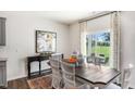 Bright dining room with large window, stylish chairs, and hardwood floors at 20 Granite Falls Way, Youngsville, NC 27596
