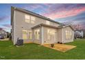 The back exterior of this home includes a simple concrete patio surrounded by green grass at 2005 Ernesto Ln, Raleigh, NC 27603