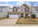 Inviting two-story home boasts a stone facade, two-car garage, and well-manicured lawn at 2005 Ernesto Ln, Raleigh, NC 27603