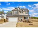 Beautiful two-story home featuring a two-car garage, lush lawn, and a welcoming front porch at 252 Olde Place Dr, Zebulon, NC 27597