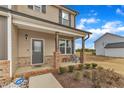 Inviting front porch with brick accents and a cozy seating area, perfect for relaxing outdoors at 252 Olde Place Dr, Zebulon, NC 27597