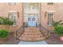 Close up of home's entrance with charming light blue doors, brick steps and wrought iron railings at 2602 Vintage Hill Ct, Durham, NC 27712
