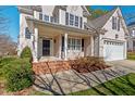 Inviting front porch with brick steps, white pillars, and a well-kept garden area at 2812 Ashland Dr, Durham, NC 27705