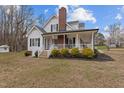 Exterior view of home featuring a porch, white trim, and manicured landscaping at 3068 Benson Rd, Angier, NC 27501