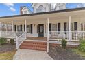 Inviting front porch with white railings, brick steps, and classic black shutters at 3068 Benson Rd, Angier, NC 27501