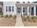 Close up of charming home with a covered front porch, perfect for relaxing and enjoying the outdoors at 372 Natsam Woods Way, Wake Forest, NC 27587