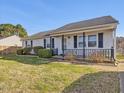 Traditional one-story home with dark shutters, covered porch, and manicured landscaping at 4 Hannah Ct, Durham, NC 27713