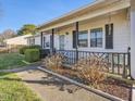 Cozy front porch with dark railing, small garden, and access to the home's entrance at 4 Hannah Ct, Durham, NC 27713
