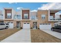 Modern townhome exteriors featuring a mix of stone, wood, and stucco with private balconies and attached garages at 4007 Southpoint Landing Way, Durham, NC 27707