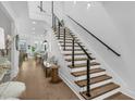 Modern wood staircase with metal railing open to the living area and dining at 4007 Southpoint Landing Way, Durham, NC 27707