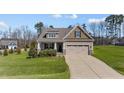 Charming home with a manicured lawn, covered porch, and a driveway leading to the attached garage at 420 Carsons Creek Trl, Wendell, NC 27591