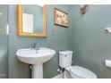 A bathroom with a green wall, white toilet, and sink at 60 Silent Brook Trl, Franklinton, NC 27525