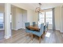 Dining room with a wooden table, six blue upholstered chairs, and natural light from large windows at 60 Silent Brook Trl, Franklinton, NC 27525