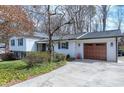 Side view of a beautifully maintained house with a two-car garage and a well-kept lawn and mature landscaping at 6812 Valley Dr, Raleigh, NC 27612