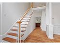Grand foyer featuring hardwood floors and a staircase with wooden handrail at 725 Littleleaf Ct, Holly Springs, NC 27540