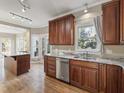 Eat-in kitchen boasts granite countertops, wood cabinets, and stainless steel dishwasher at 725 Littleleaf Ct, Holly Springs, NC 27540