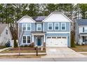Inviting two-story home with a light blue exterior, white trim, a two-car garage, and a tidy front yard at 741 Moonbeam Dr, Raleigh, NC 27603