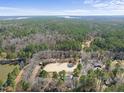 Expansive aerial shot of a horse farm surrounded by lush woodlands and a serene lake at 8809 Farrington Mill Rd, Chapel Hill, NC 27517