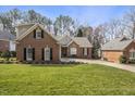 Attractive brick house with a well-maintained lawn and beautiful, mature trees at 933 Tanworth Dr, Raleigh, NC 27615