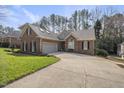 Brick home with attached garage, lush lawn, and long driveway at 933 Tanworth Dr, Raleigh, NC 27615