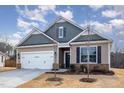 Inviting single-Gathering home featuring a two-car garage, classic siding, and a neat front yard with young trees at 10 Parker Pond Ct, Durham, NC 27703