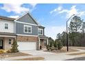 Two-story townhome boasting a brick and siding exterior with a two-car garage and well-kept landscaping at 1000 Pyrenees Way, Cary, NC 27519