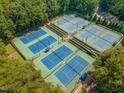 Aerial view of tennis courts surrounded by lush trees, offering a serene and active community amenity at 101 Rustic Wood Ln, Cary, NC 27518