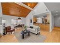 Open-concept living room featuring a high ceiling, wood accents, hardwood flooring, and natural light at 1011 Oxbow Crossing Rd, Chapel Hill, NC 27516