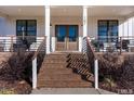 Inviting front porch with a brick staircase, modern railing, and a double front door at 107 Crescent Hill Ln, Rougemont, NC 27572