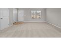 Bright living room with neutral carpet, a window, and a white door at 1122 Briar Rose Ln, Durham, NC 27704