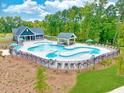 An aerial view of a community pool surrounded by lush greenery, lounge chairs, and a covered seating area at 124 Hemlock Falls Trl # 189, Raleigh, NC 27603