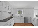 Bright kitchen with white cabinets, stainless steel appliances, and a garden window at 12516 Shallowford Dr, Raleigh, NC 27614