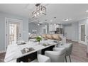 Dining room with a marble top table, modern lighting, and open floor plan to the living room and kitchen at 127 Landfall Ln, Smithfield, NC 27577