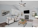 Bright living room features a fireplace, ceiling fan, and seamlessly connects to the dining and kitchen areas at 127 Landfall Ln, Smithfield, NC 27577