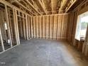 Spacious, unfinished living room highlighting the framework and concrete flooring with window views at 20 Trescott St, Smithfield, NC 27577