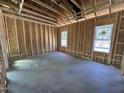 Unfinished room showing wood frame construction, concrete flooring, and natural light from windows at 20 Trescott St, Smithfield, NC 27577