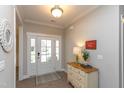 Inviting entryway features a white door with sidelights, a decorative mirror, and a stylish console table at 2059 Dowell Ct, Burlington, NC 27215