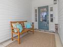Inviting front porch area with a cozy bench and stylish, teal-colored front door entrance at 2059 Dowell Ct, Burlington, NC 27215