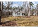 A quaint single-story home featuring classic siding, black shutters, and a serene natural setting at 2120 Canterbury Rd, Clayton, NC 27520